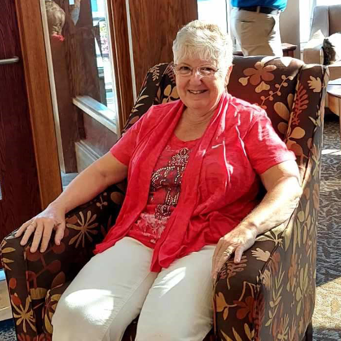 Carol sitting in chair bank lobby